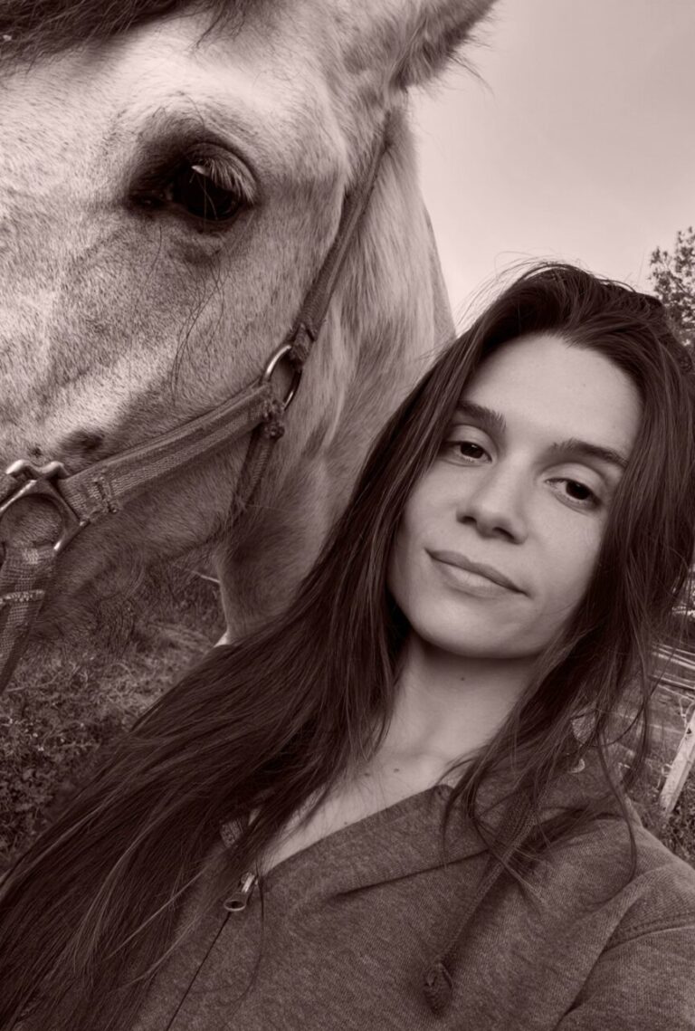 Fotografía en tono sepia de una mujer junto a un caballo, en primer plano.