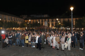 Multitud reunida de noche en una plaza iluminada de Palencia