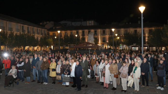 Multitud reunida de noche en una plaza iluminada de Palencia