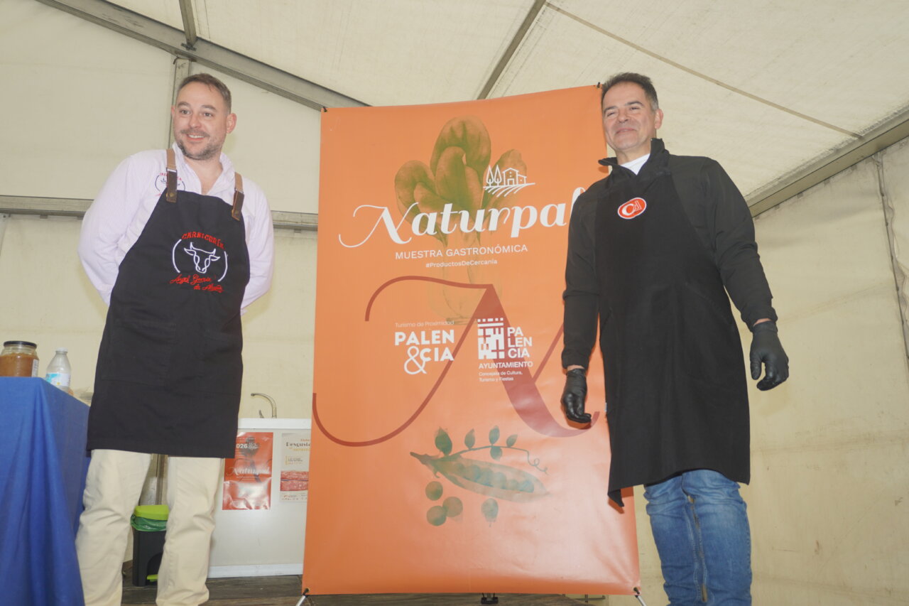 Dos carniceros en la feria Naturpal mostrando hamburguesas