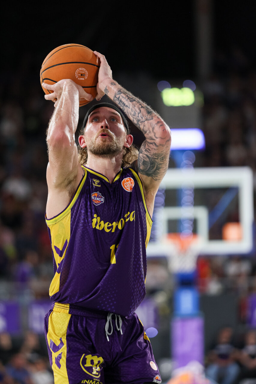 Jugador de baloncesto lanzando a canasta en un partido