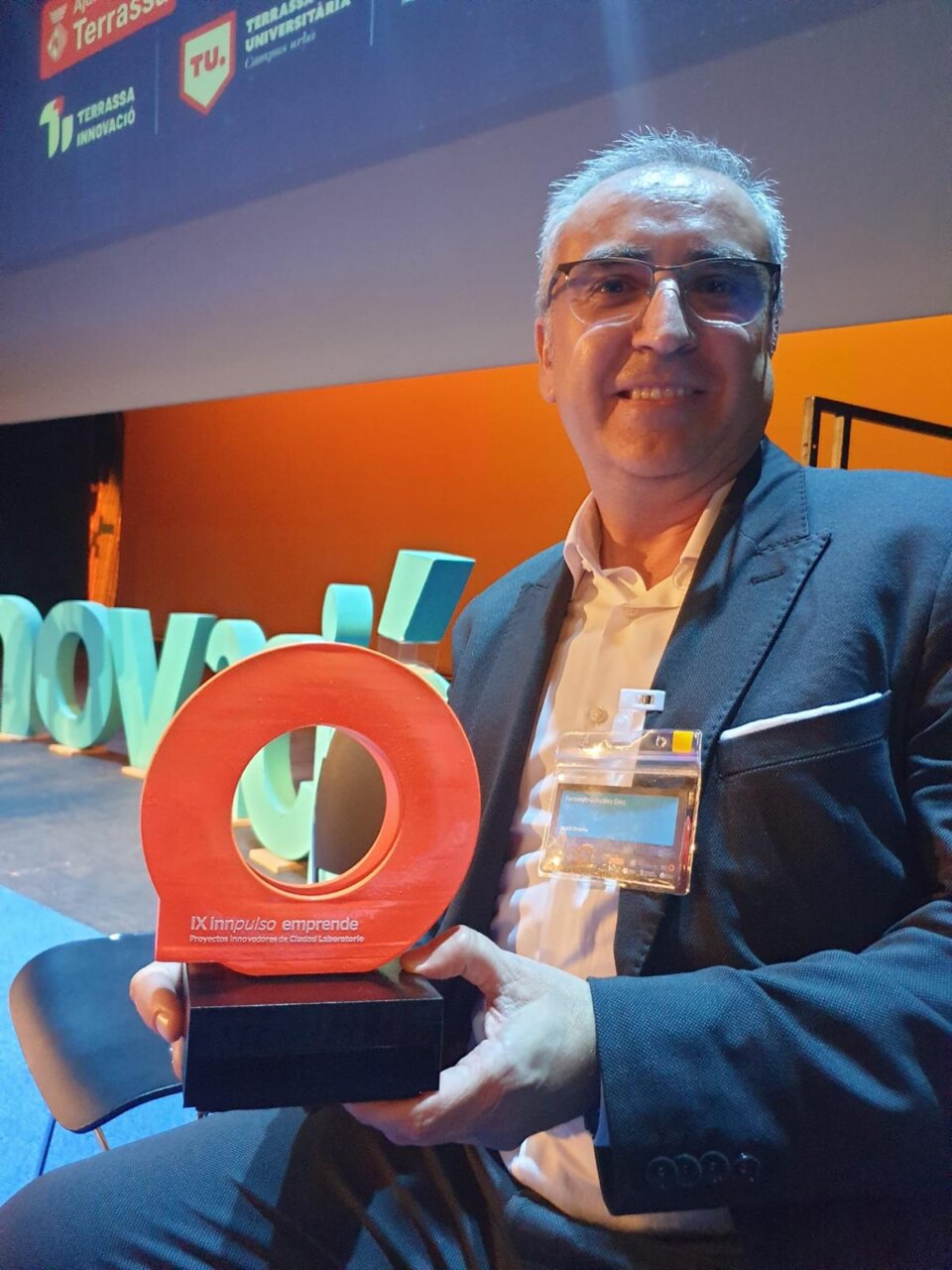 Persona sosteniendo un premio Innpulso Emprende en un evento