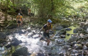 Corredores cruzando un arroyo en el Trail El Calero en Palencia