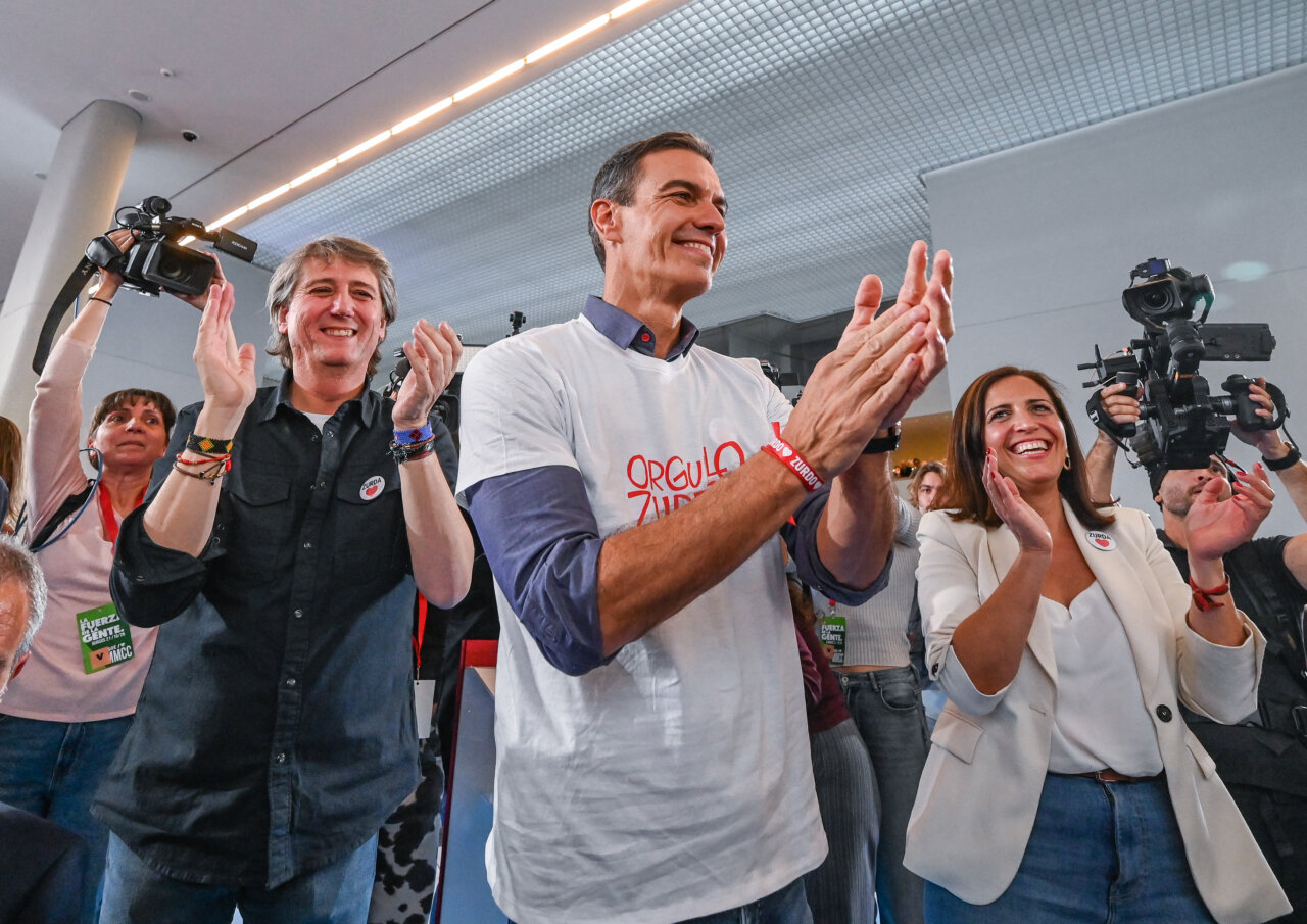 Pedro Sánchez aplaude junto a asistentes y cámaras en un acto político