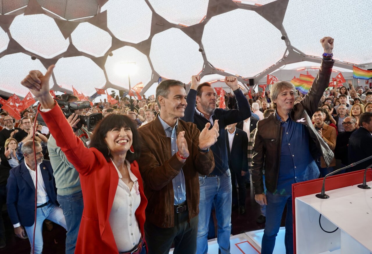 Pedro Sánchez y asistentes en un acto político bajo una cubierta geométrica