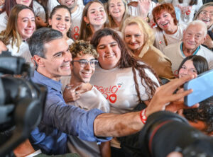 Pedro Sánchez posa para una foto con simpatizantes que visten camisetas de Orgullo Zurdo.
