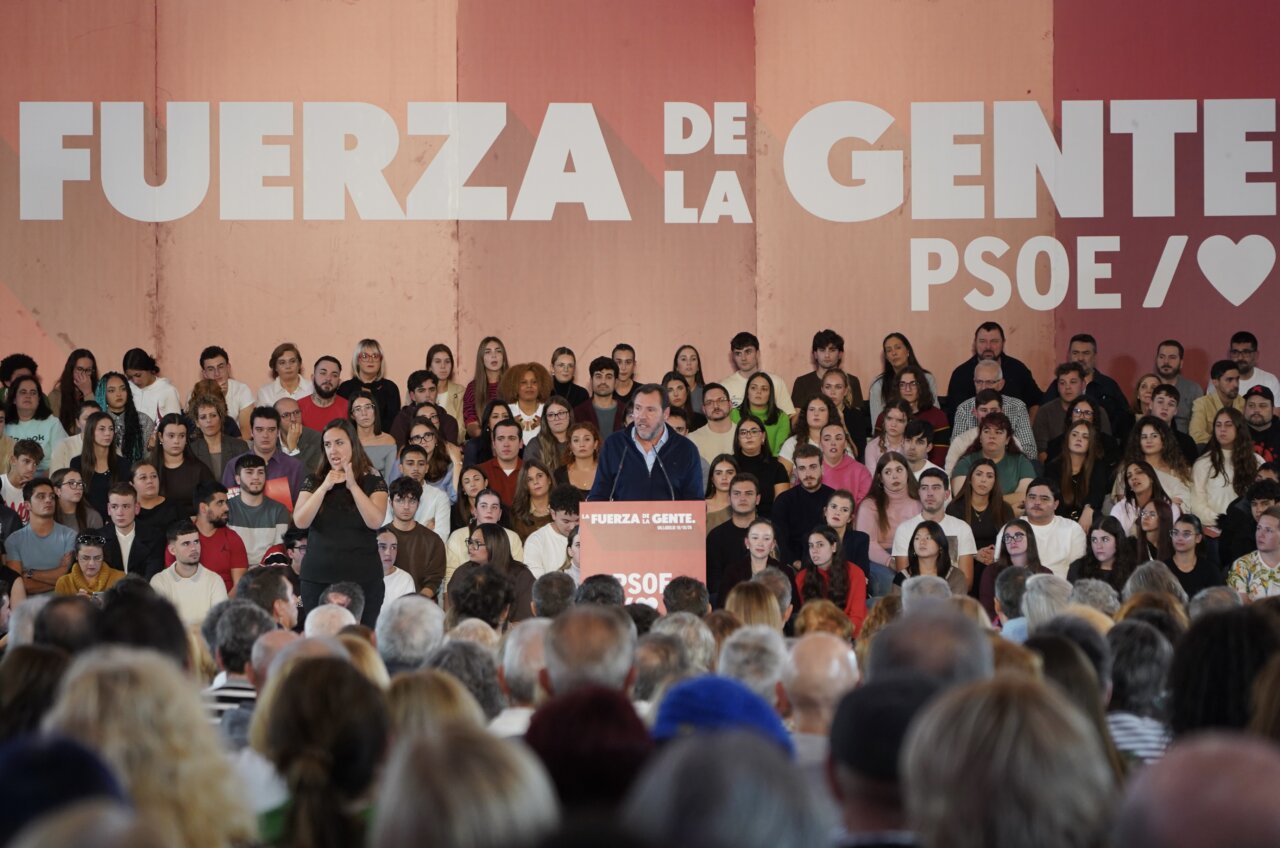 Pedro Sánchez habla desde un atril ante asistentes bajo el lema Fuerza de la Gente.
