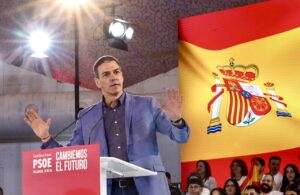 Pedro Sánchez habla desde un atril del PSOE ante una bandera española y asistentes