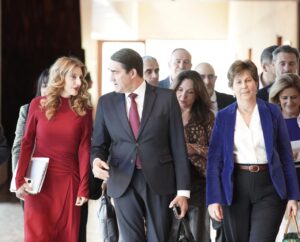 Varias personas caminan juntas por el interior de un edificio iluminado.