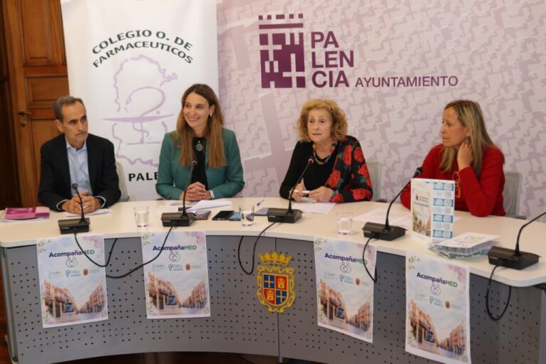 Cuatro personas sentadas ante una mesa con carteles de AcompañaMED y logos institucionales.