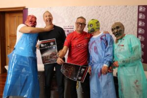 Varias personas posan con disfraces de terror y carteles de Halloween en Palencia