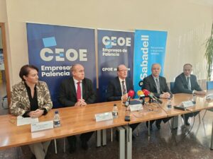 Cinco personas sentadas ante micrófonos, con pancartas de CEOE Palencia y Banco Sabadell.