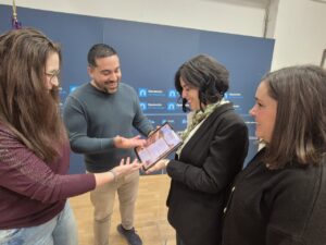 Cuatro personas observan una tableta frente a un fondo de la Diputación de Palencia.