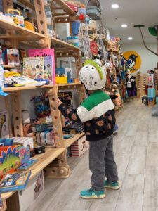 Una persona observa juguetes y libros en estanterías de una tienda