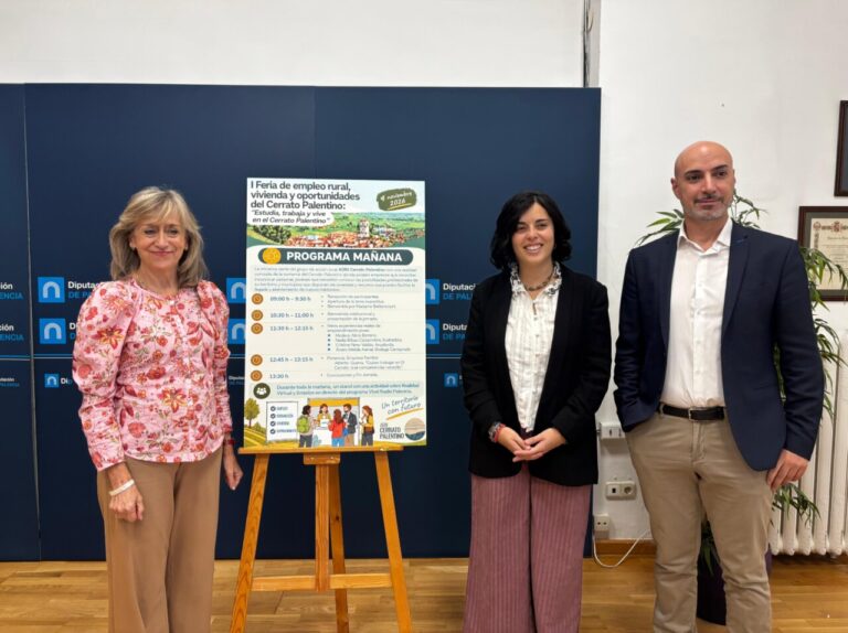 Tres personas posan junto al cartel de la feria de empleo rural del Cerrato.