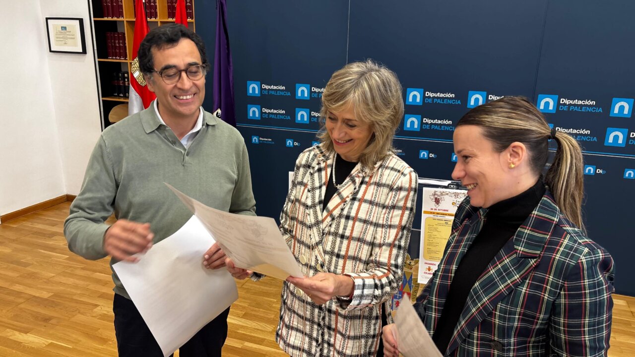 Tres personas revisan documentos ante un panel de la Diputación de Palencia.