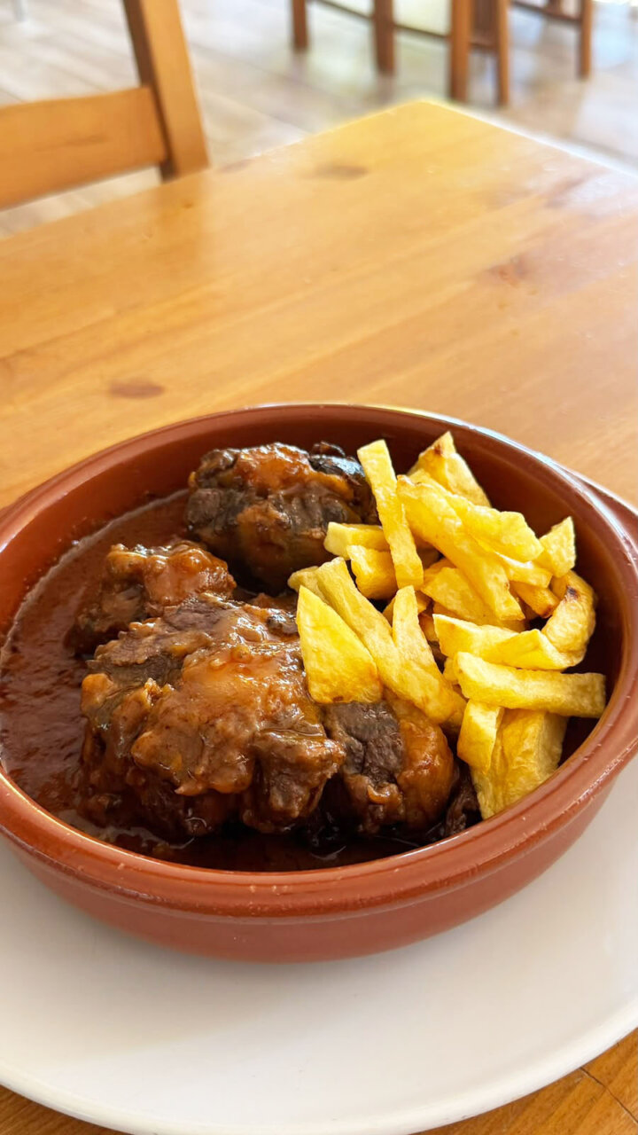 Plato de rabo de toro con patatas fritas en restaurante El Matadero
