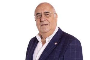 Retrato de Agustín Martínez García con gafas y chaqueta azul sobre fondo blanco.