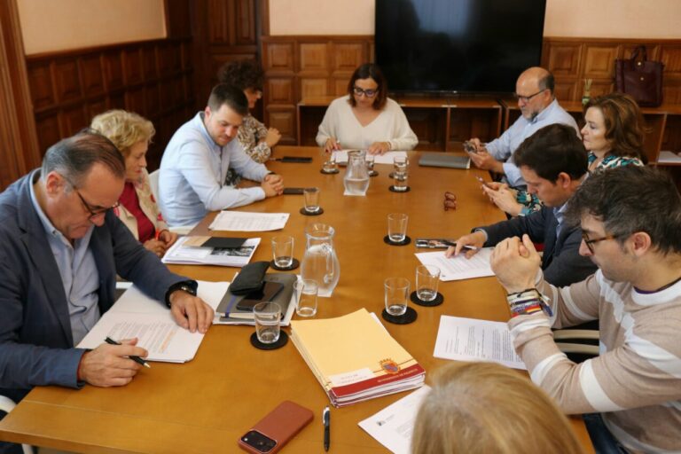 Personas reunidas alrededor de una mesa con documentos en una sala municipal de Palencia