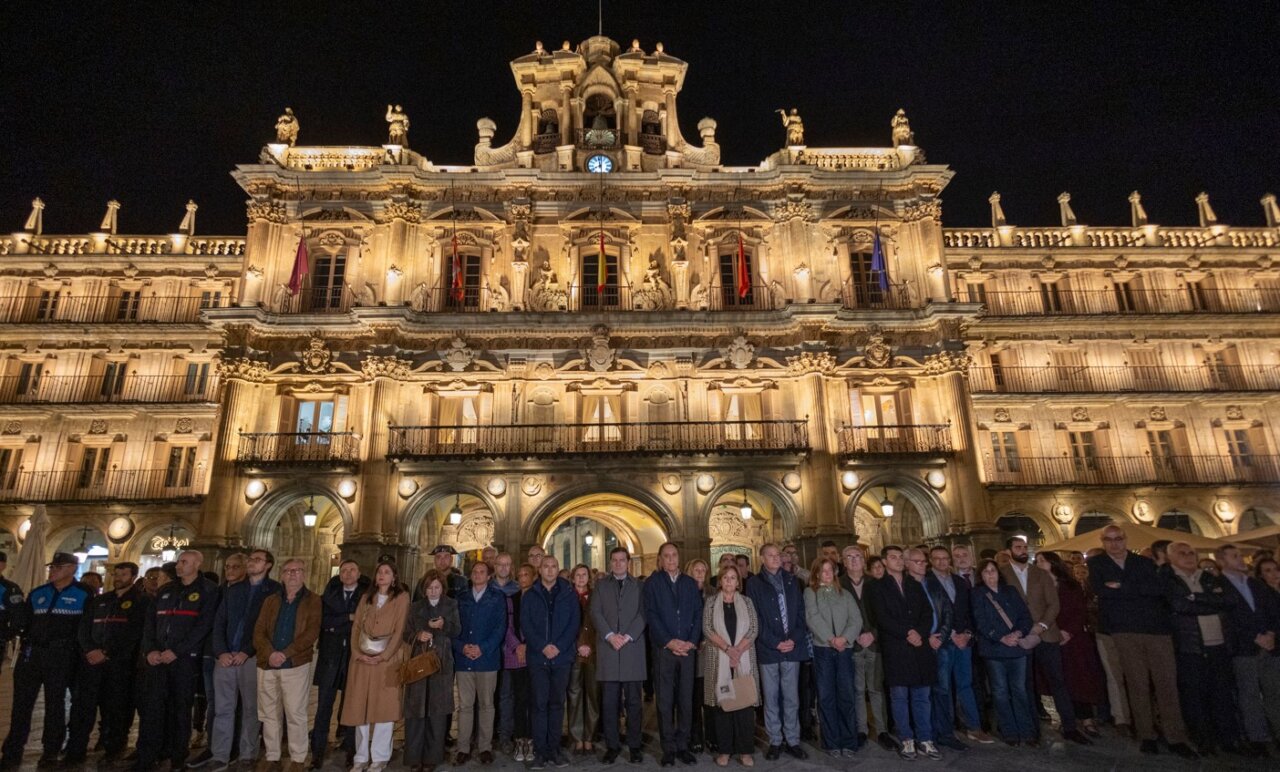 Personas reunidas de noche frente a un edificio iluminado en la plaza Mayor de Salamanca.