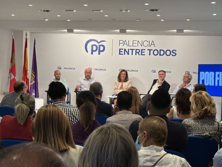 Personas sentadas en una sala escuchan a varios participantes en una mesa del PP Palencia.