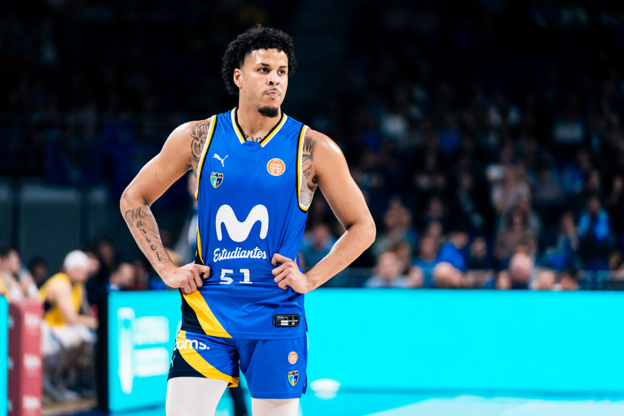Jugador del Estudiantes con uniforme azul posa con las manos en la cintura durante un partido
