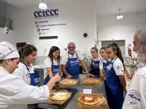 Grupo de personas en un taller de cocina preparando pizzas