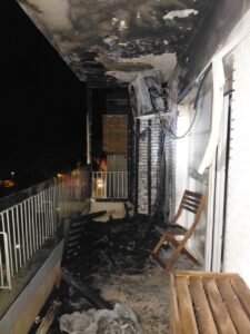 Terraza con paredes y techo ennegrecidos, restos quemados y mobiliario tras un incendio